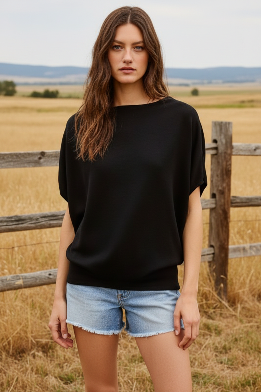 Black dolman sleeve top with denim shorts and western boho ranch background