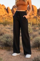 Black wide-leg drawstring pants with desert landscape