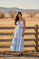 Blue and white striped two-piece set with crop top and tiered maxi skirt with western boho ranch background