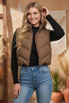 Brown puffer vest on model with styled background