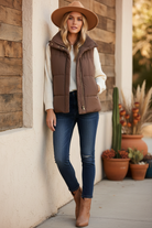 Brown puffer vest on model with styled background