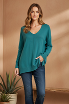 Brown v-neck sweater on model with styled background