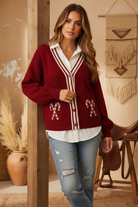 Burgundy candy cane cardigan on model with styled background