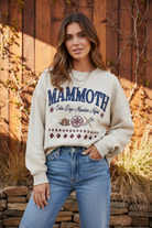Cream Mammoth graphic sweatshirt on model with styled background