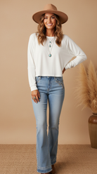 Cropped white long-sleeve top on model