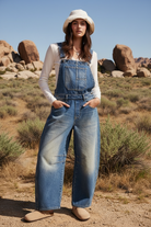 Distressed denim wide leg overalls with desert landscape