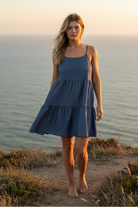 Dusty blue tiered mini dress with coastal cliff background