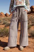 Gray cargo wide leg pants with contrast stitching and desert landscape