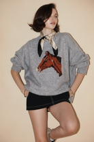 Gray horse sweater with soft neutral background