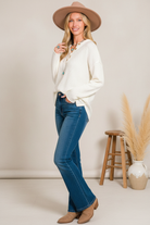 Ivory textured sweater with button details on model