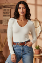 Ivory v-neck long sleeve top on model with styled background