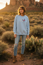 Light blue butterfly sweatshirt with desert landscape