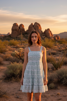 Light blue floral tiered mini dress with centered model and desert landscape