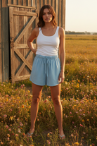 Light blue paperbag waist drawstring shorts with white tank top