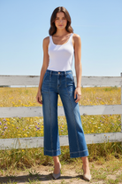 Medium dark wash wide leg cropped jeans with white tank top in bright boho western setting