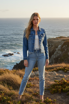 Medium wash denim jacket with coastal cliff background