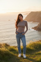 Mocha long sleeve crop top with coastal cliff background