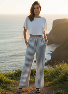 Navy and white striped wide leg pants with coastal cliff background - front view