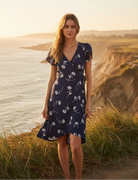 Navy floral wrap dress with coastal cliff background