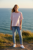 Pink and white striped oversized tee with coastal cliff background