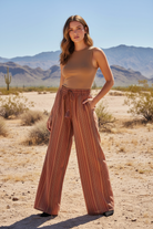 Rust orange striped wide leg pants with brighter desert landscape