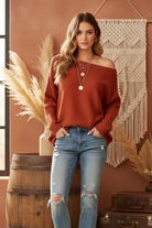 Rust ribbed sweater on model - off one shoulder