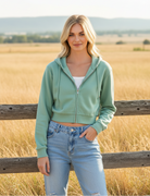 Sage green cropped zip-up hoodie with western boho ranch background