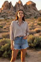 Taupe and white striped shirt with denim shorts and desert landscape