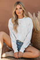 White cream camo crew neck sweatshirt on model with styled background