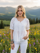 White eyelet embroidered top with mountain meadow background