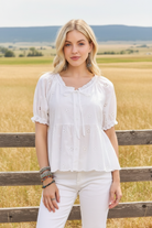 White eyelet peasant top with tie neckline and western boho ranch background
