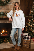 White Happy Golden Days graphic sweatshirt on model with Christmas background
