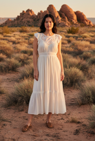 White tiered midi dress with ruffle sleeves and desert landscape